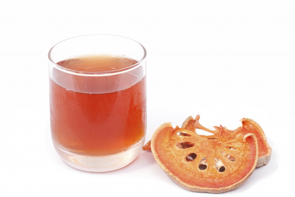 Bael fruit and juice isolated on the white background